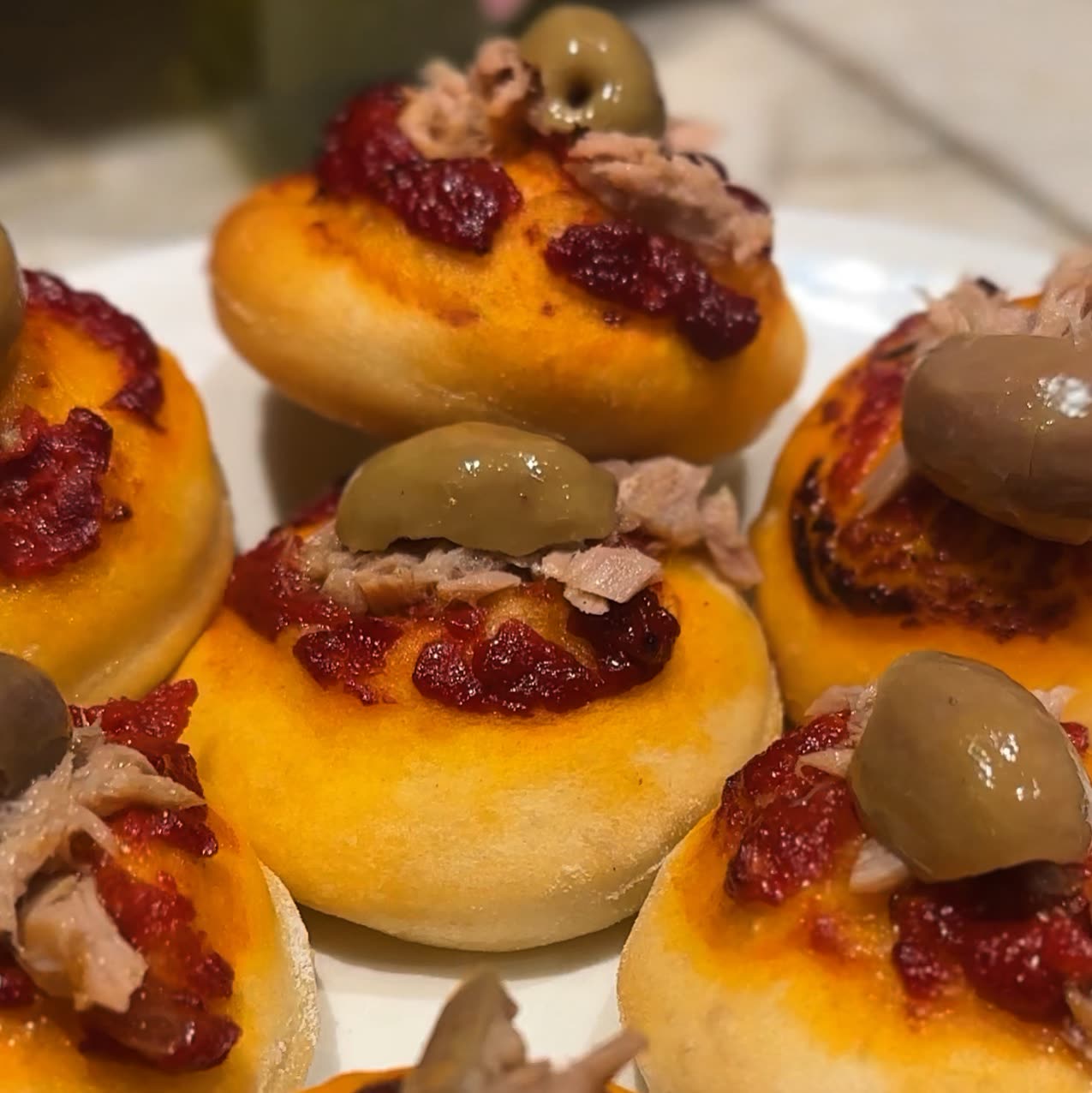 Petits pains briochés garnis de sauce tomate, de thon et d'olives