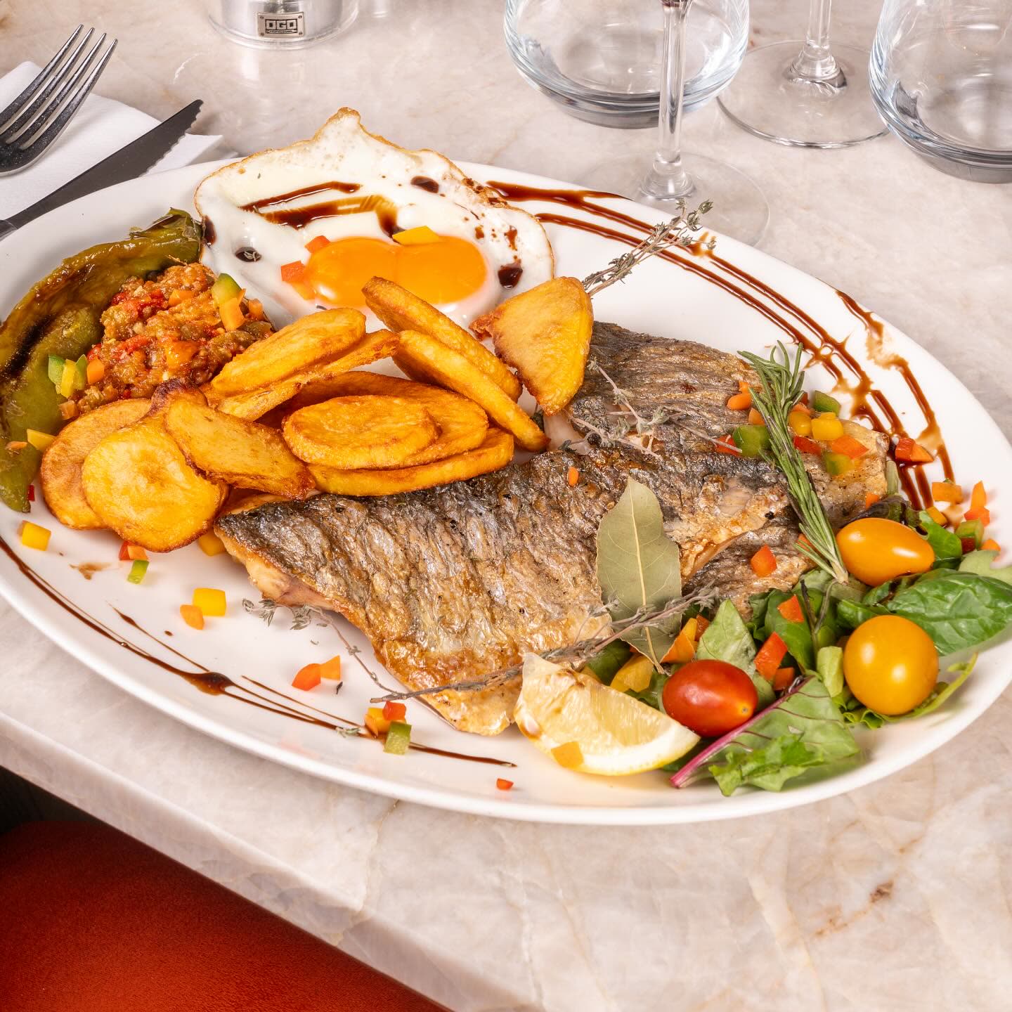 Un plat de poisson grillé accompagné de pommes de terre et de légumes