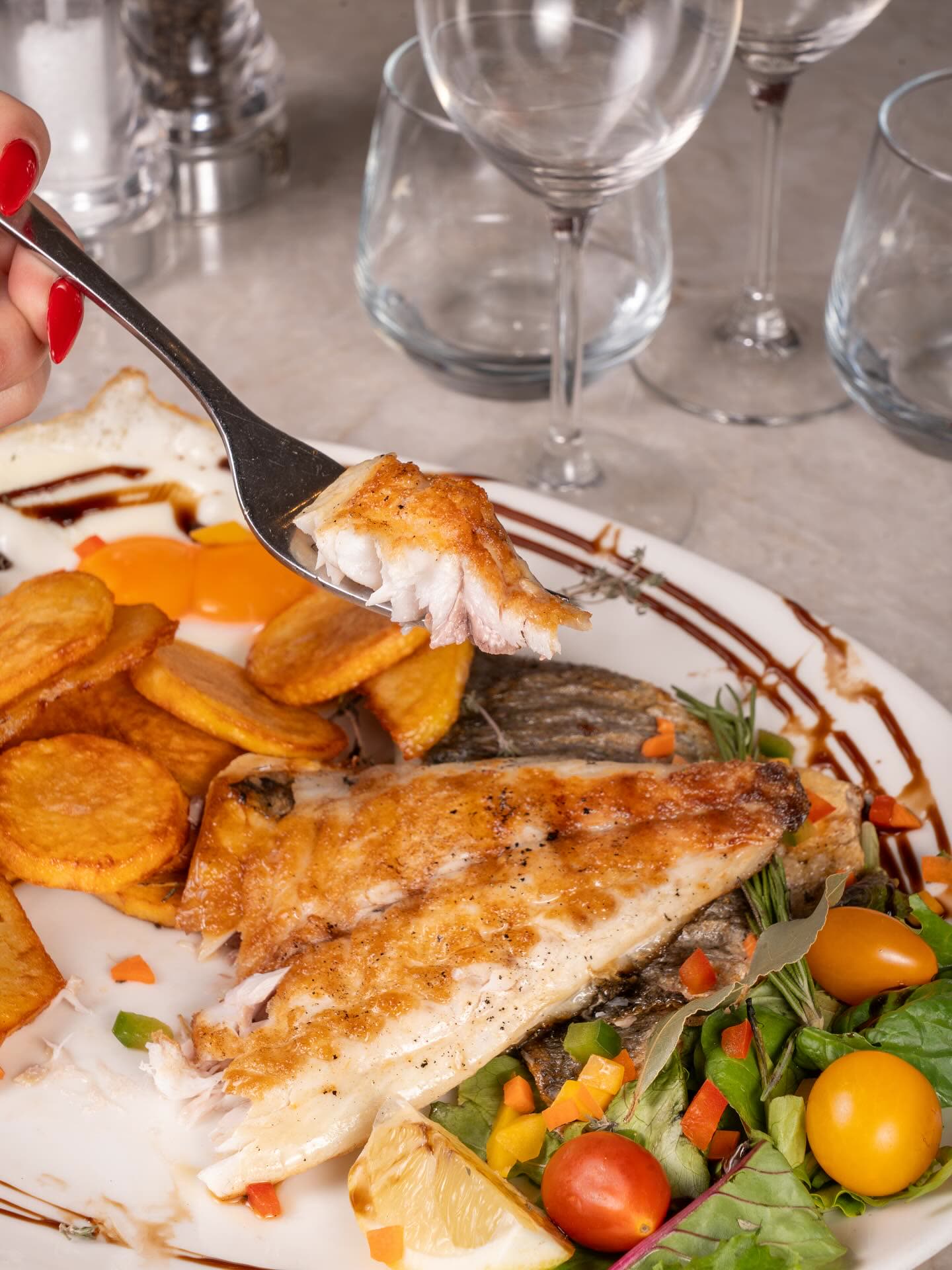Un filet de poisson grillé servi avec des pommes de terre et une salade