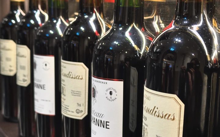 Plusieurs bouteilles de vin rouge alignées sur une étagère